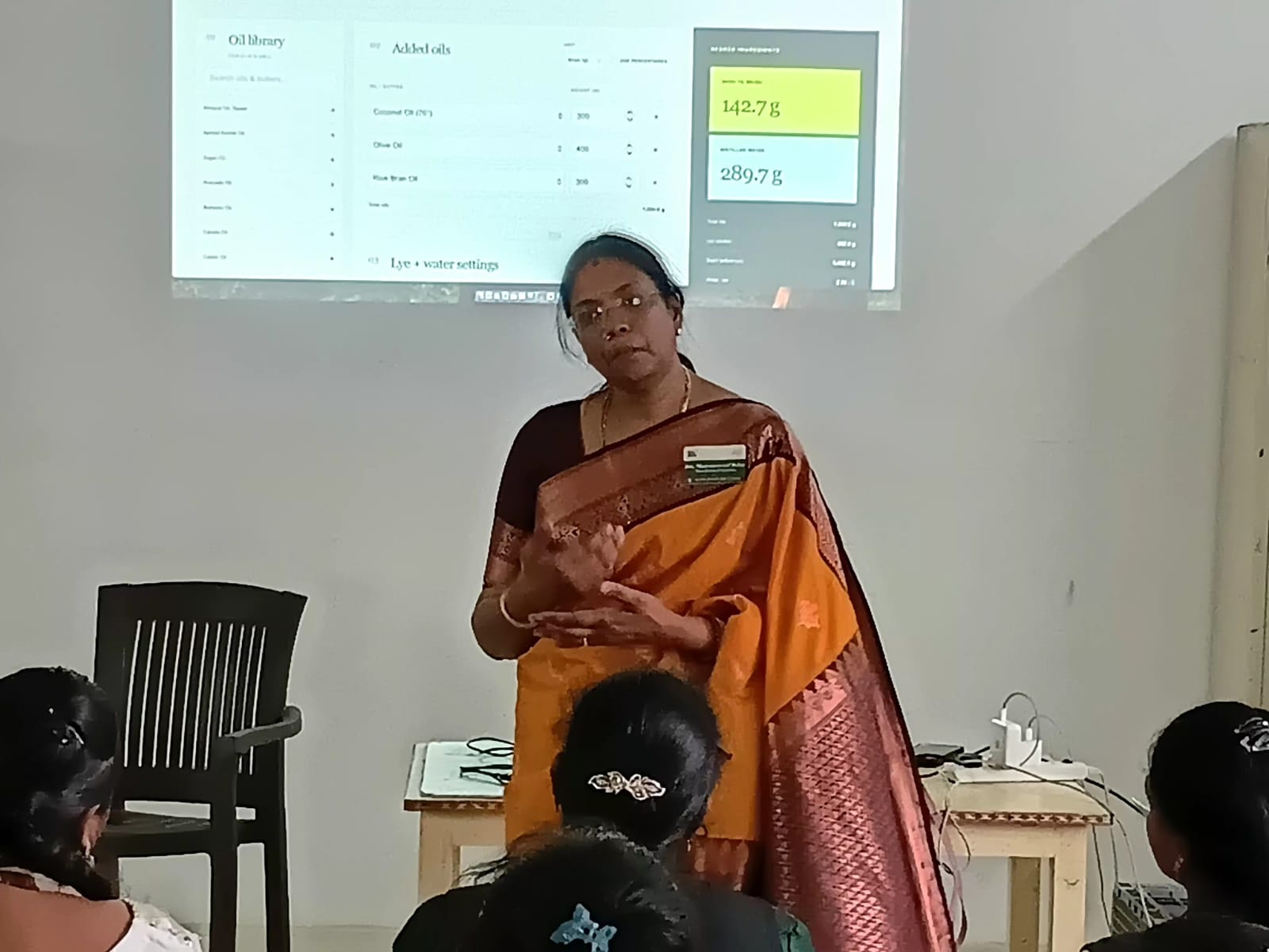 Instructor explaining a soap formulation presentation to participants